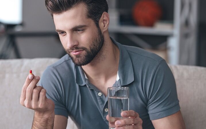 muškarac pije tabletu za povećanje glave penisa
